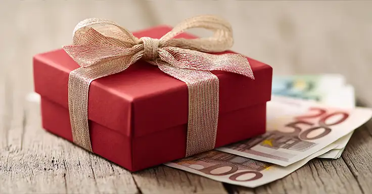 Rote Geschenkbox mit Schleife auf Euro-Geldscheinen